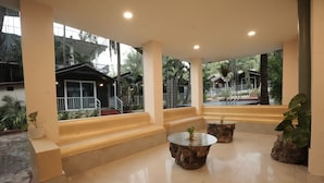 Un espacio interior amplio con una zona de estar, una escalera y vistas al exterior.