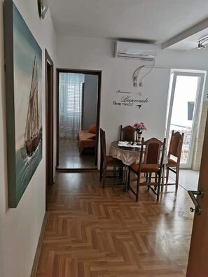 A hallway with a dining area, a mirror, and a wall-mounted air conditioner. - Apartments Marija (Trogir)