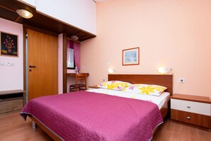 Ein Schlafzimmer mit einem Bett, Nachttischen, einem Schreibtisch und einem Sessel.