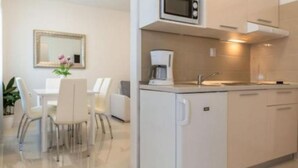 Une cuisine compacte équipée d’un four à micro-ondes, d’une machine à café et d’un petit réfrigérateur.
