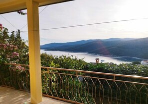Ein Balkon mit Blick auf einen See und Berge.
