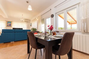Eine moderne Küche mit Esstisch, Stühlen und einem blauen Sofa.