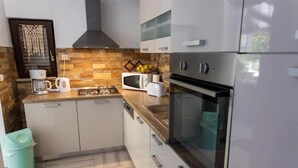 A modern kitchen with a microwave, toaster, and stove. - House Ivana (Milna)