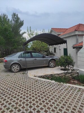 Ein Auto parkt auf einer Einfahrt unter einem überdachten Carport.