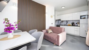 Une cuisine moderne avec des meubles blancs, un pare-feu en marbre et des appareils électroménagers en acier inoxydable.