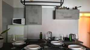 Une cuisine moderne équipée d’un four à micro-ondes encastré, d’une cuisinière à gaz et d’un luminaire suspendu.