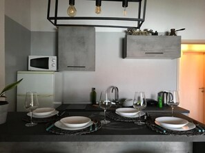 Eine moderne Küche mit integriertem Mikrowellenherd, Gasherd und einer Pendelleuchte.