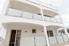 A multi-story building with balconies, large windows, and a door. - Apartments Jozak (Trogir)