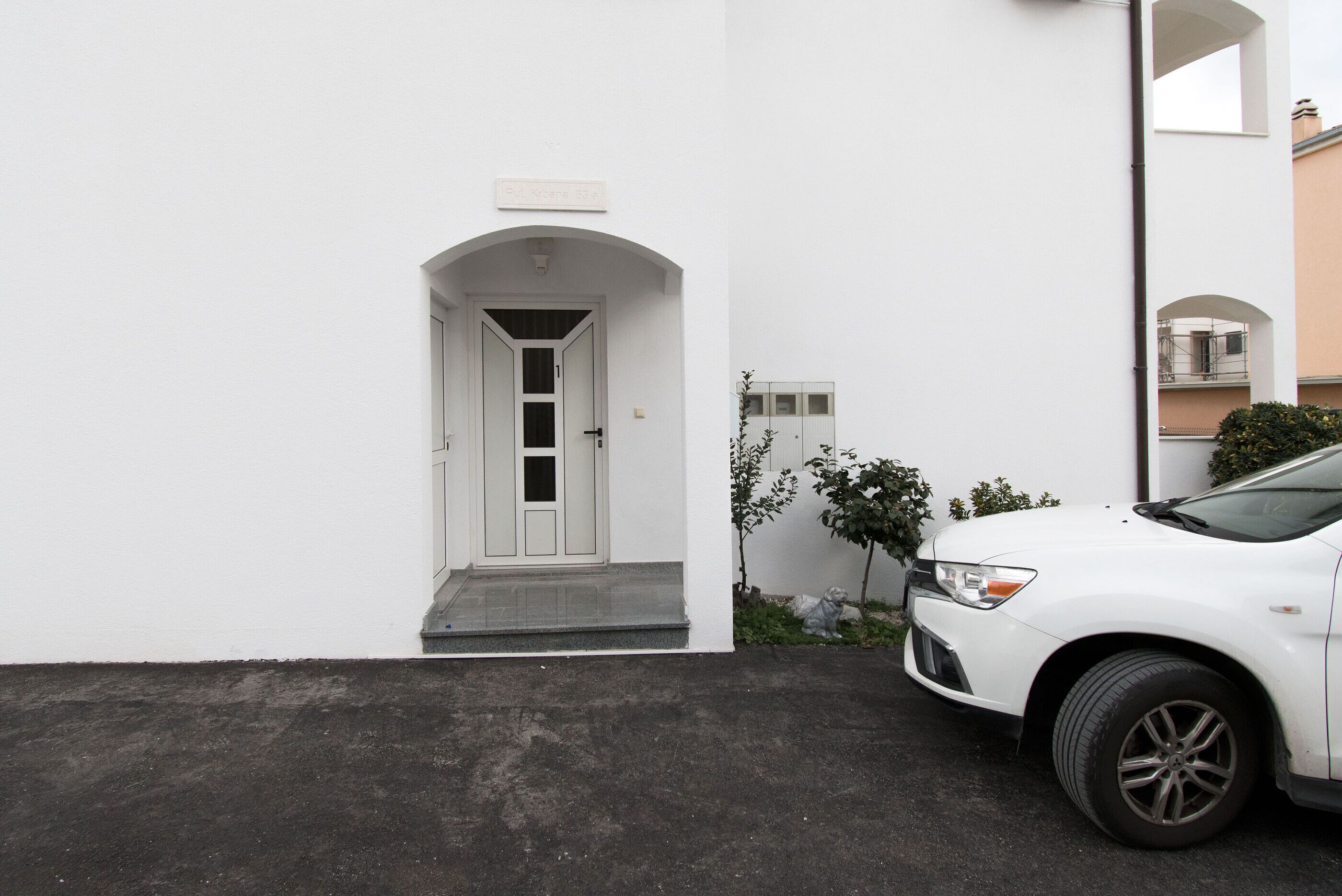 A white building with a white door and a small porch.