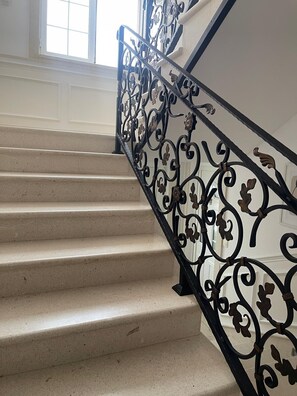 A staircase with a black wrought iron railing and beige steps. - Apartments Luna Aurea (Orebic)