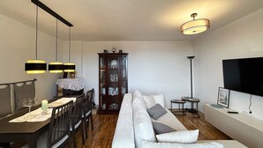 A modern living room with a dining area, a sofa, a TV, and a cabinet. - House Martin (Vinodol)