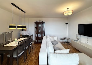 A modern living room with a dining area, a sofa, a TV, and a cabinet. - House Martin (Vinodol)