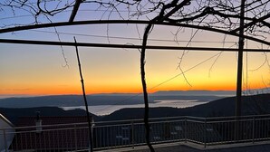 A balcony with a metal railing overlooking a sunset view. - House Martin (Vinodol)