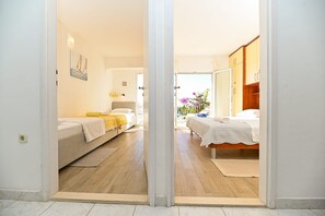 Ein Hotelzimmer mit zwei Betten, Holzboden und Blick ins Freie.
