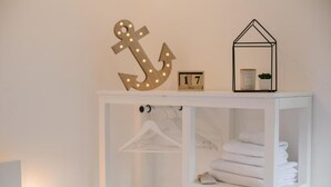 A white shelf with a wooden anchor, a framed picture, and a date card. - Apartment Skatula Skradin (Skradin)