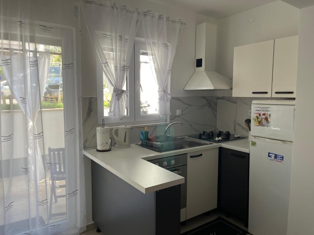 A compact kitchen with a sink, stove, and a refrigerator.