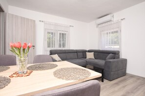 Ein modernes Wohnzimmer mit einem grauen Sofa, einem Holztisch und einer Vase mit Blumen.