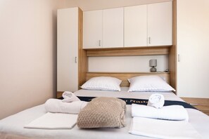 Ein Hotelzimmer mit einem Bett, einem Holzschrank und einem Nachttisch mit Lampe.