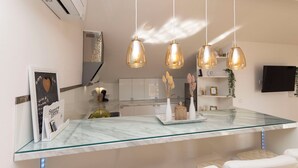 A modern kitchen with a marble countertop, pendant lights, and a built-in TV. - Apartments VV Adriatic Panorama (Vodice)