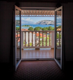 Ein Zimmer mit Balkon und Blick auf eine malerische Seen- und Berglandschaft.