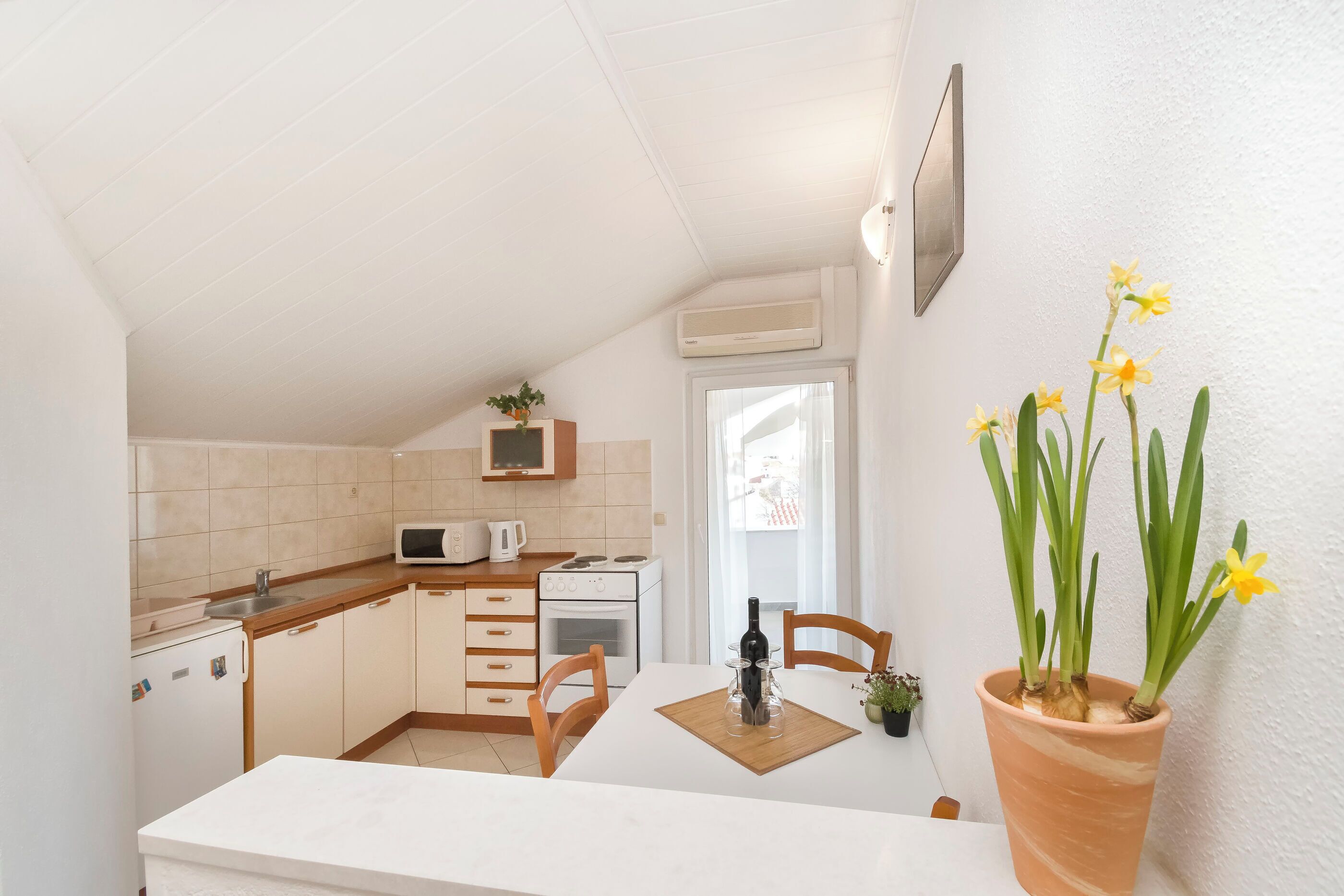 A compact kitchen with a microwave, stove, and cabinets.