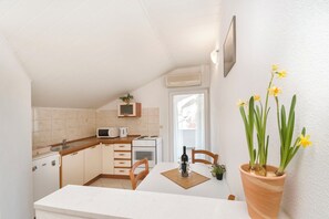 A compact kitchen with a microwave, stove, and cabinets. - Apartments Skriveni Dvori (Vodice)