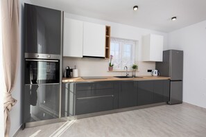 Eine moderne Küche mit Edelstahlgeräten, Holz Arbeitsplatten und weißen Schränken.
