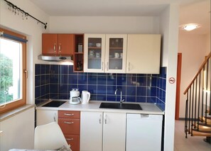 A compact kitchen with a sink, coffee maker, and cabinets. - Apartment Adri (Rovinj)