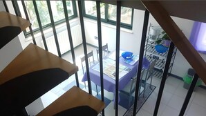 Un intérieur moderne situé dans un immeuble de grande hauteur, comprenant un coin repas, une machine à café et une vue sur l’extérieur.