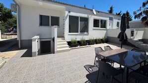 A modern house with a patio, outdoor seating, and potted plants. - Apartments Stay Near Paklenica (Starigrad)