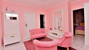A pink-themed bedroom with a vanity, two pink chairs, a white dresser, and a large mirror. - Apartment Villa Zizi (Viskovo)