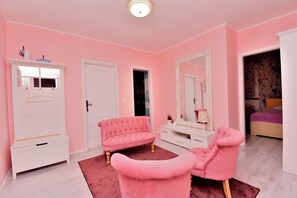 A pink-themed bedroom with a vanity, two pink chairs, a white dresser, and a large mirror. - Apartment Villa Zizi (Viskovo)