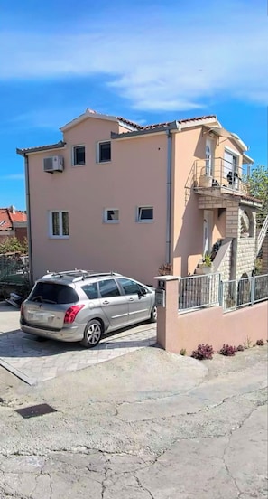 A two-story building with a car parked in front. - Apartments Zlatka (Okrug)