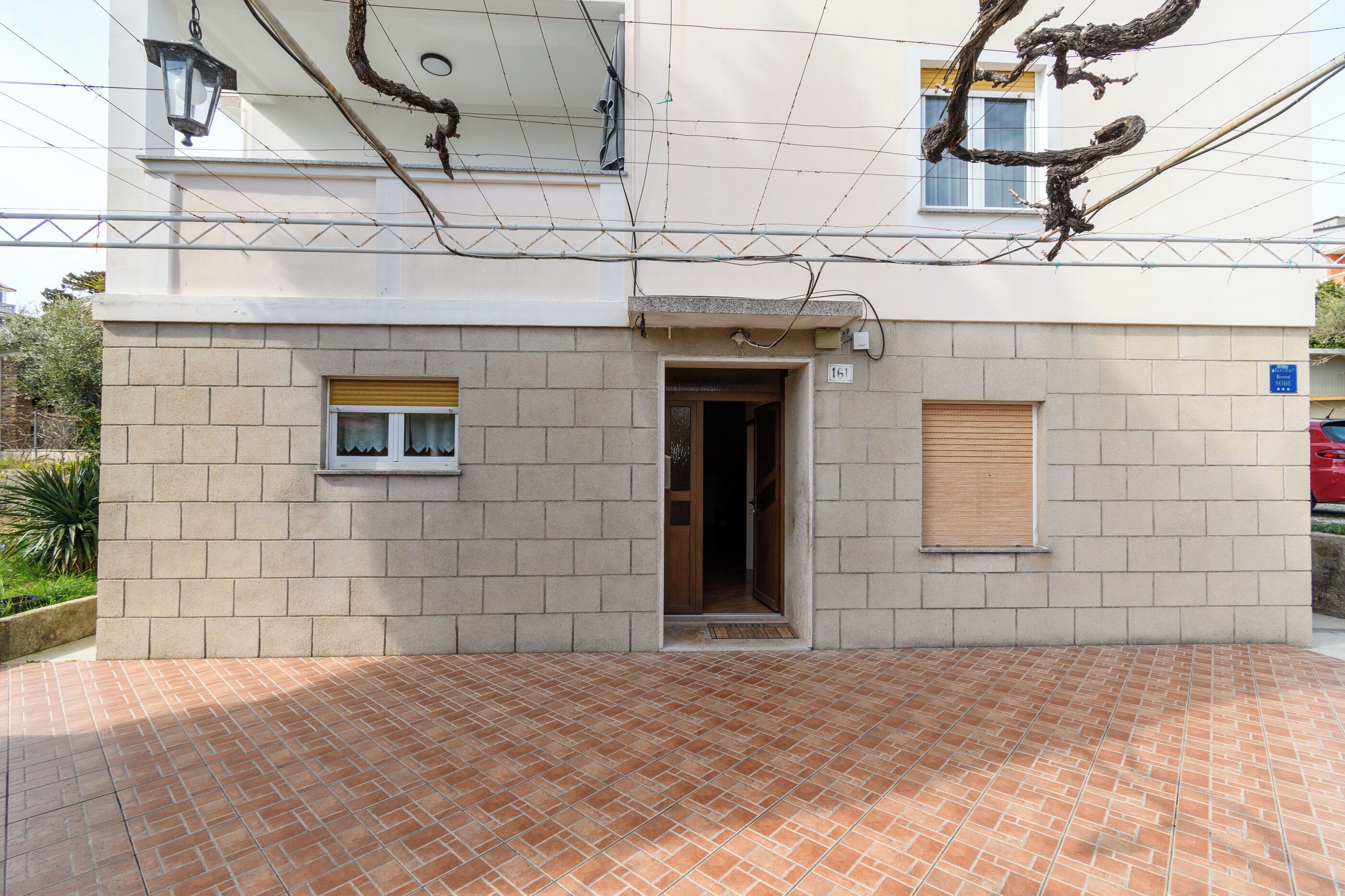A building with a tiled patio, a door, and a window.