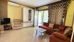 A living room with a sofa, armchair, TV, and a cabinet. - Apartments Fran (Crikvenica)