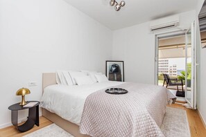 A bedroom with a bed, a nightstand, a picture frame, and a view of the outside. - Apartment Sea View Garden (Split)