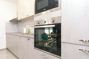 Eine Küche mit Einbau-Mikrowelle, Backofen und einem Glasfenster.