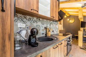 Eine moderne Küche mit Kaffeemaschine, Spüle und Holzschränken.