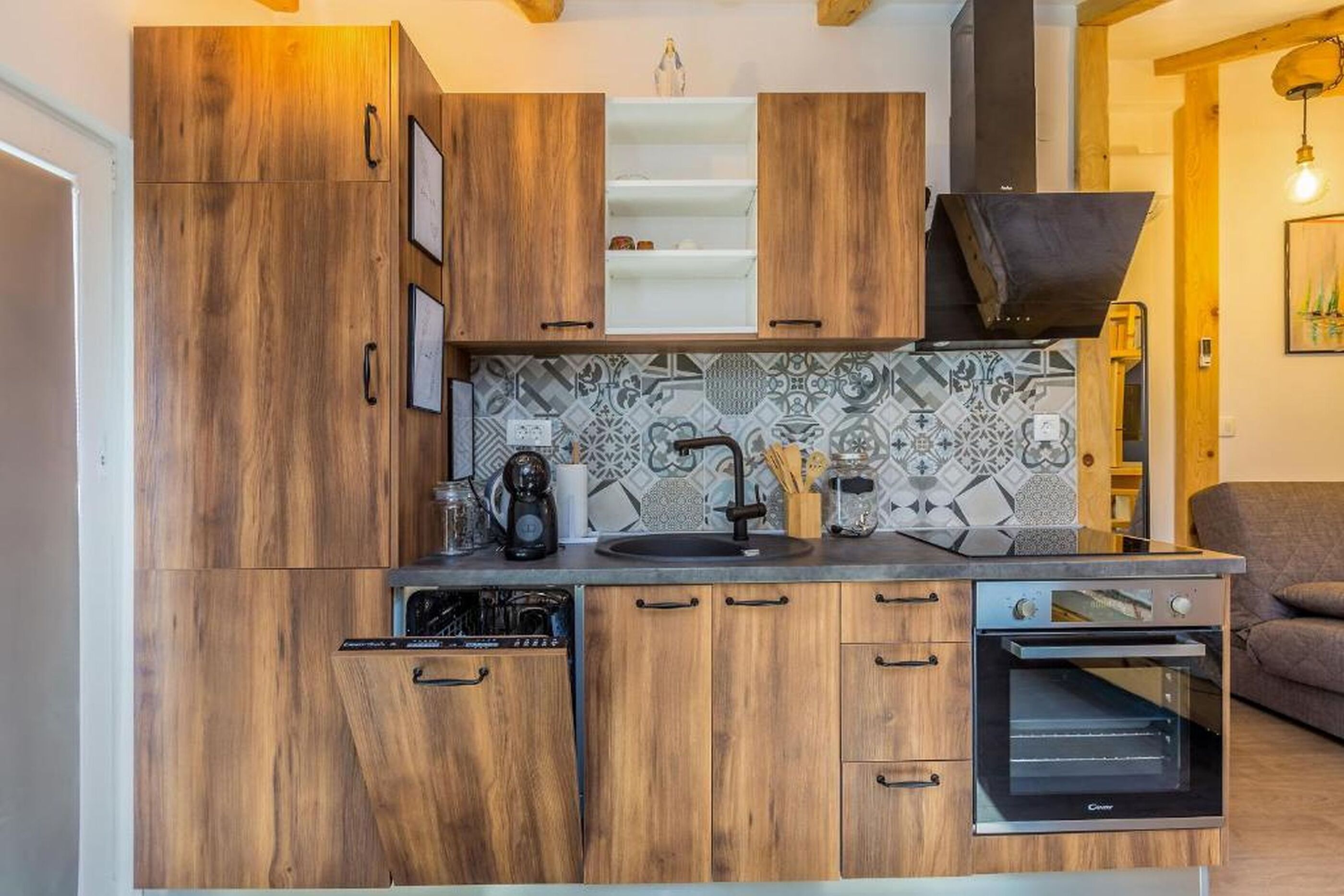 A compact kitchen with wooden cabinets, a built-in oven, and a tiled backsplash.