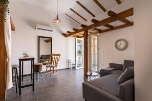 Ein Wohnzimmer mit einer Couch, einem Schaukelstuhl, einem kleinen Tisch mit Lampe und einer Pendelleuchte.