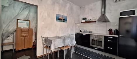 Eine moderne Küche mit Essbereich, einem eingebauten Ofen und einer Mikrowelle.