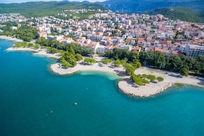 Luftaufnahme einer Küstenstadt mit Gebäuden, Stränden und klarem, blauem Wasser.