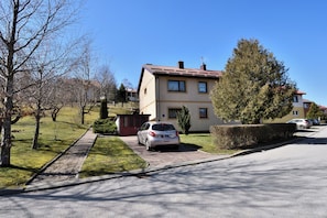 A residential building with a paved driveway and parked cars. - Apartment Tadey (Fuzine)