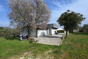 A modern house with a covered patio, a garage, and a lawn. - House Ivana (Pula)