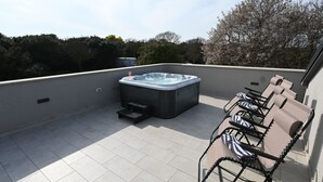 A rooftop terrace with a hot tub, outdoor seating, and a view of trees. - House Ivana (Pula)