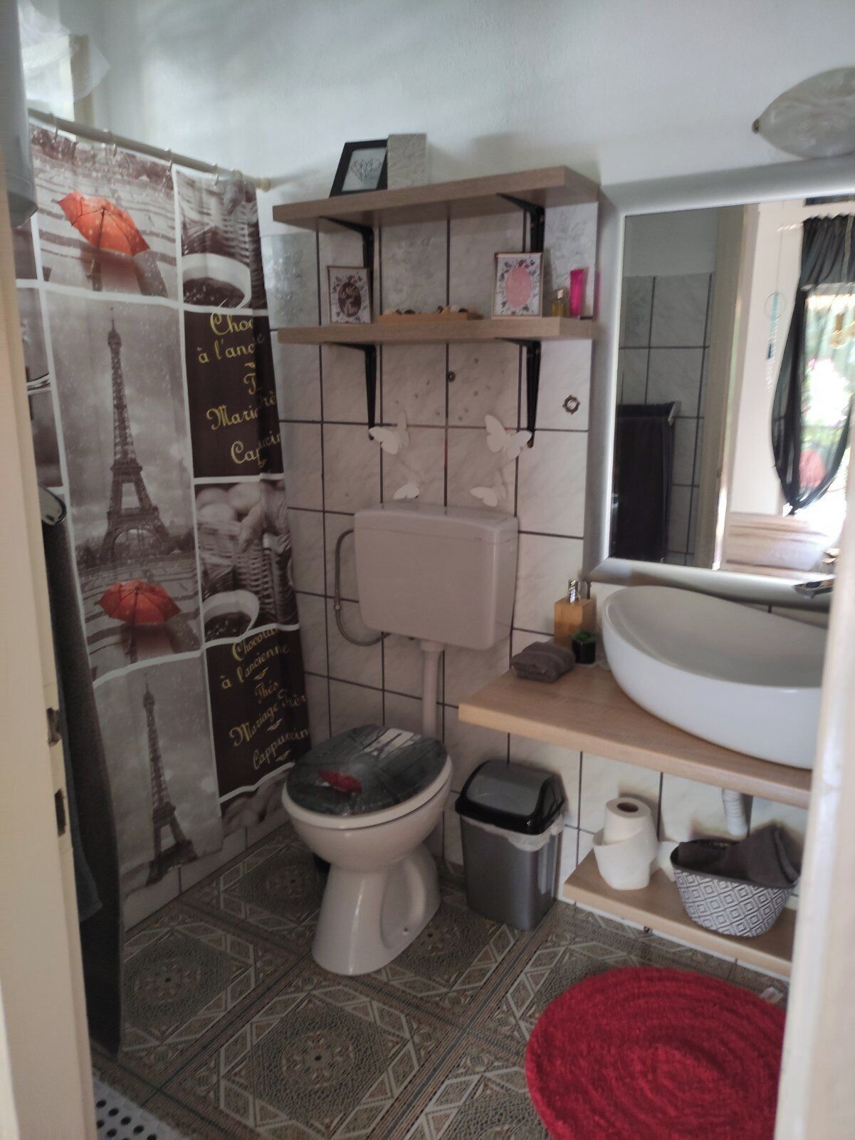 A bathroom with a toilet, sink, and shower area.