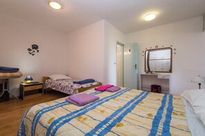 Ein Schlafzimmer mit einem großen Bett, zwei Nachttischen, einem Kleiderschrank und einem Spiegel.