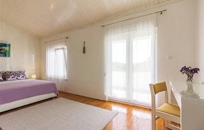 A bedroom with a bed, a chair, a desk, and a window with curtains. - House Pineta Art Home (Medulin)