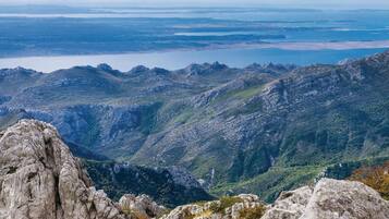 A mountainous landscape with rocky terrain and a lake in the distance.