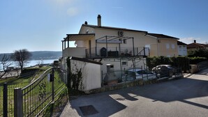 Uma casa de dois andares com varanda, garagem e vista para o mar.